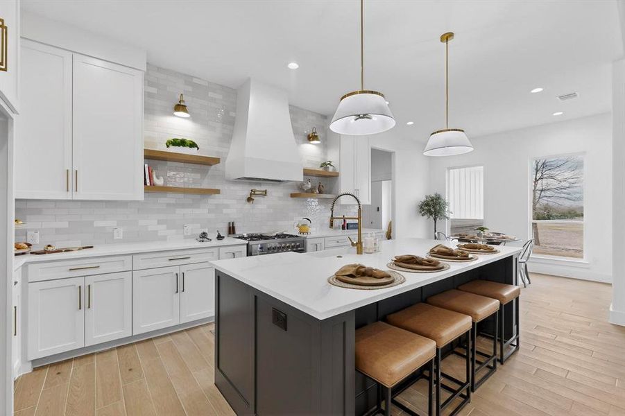 Kitchen with white cabinets, open shelves, a kitchen bar, backsplash, and recessed lighting