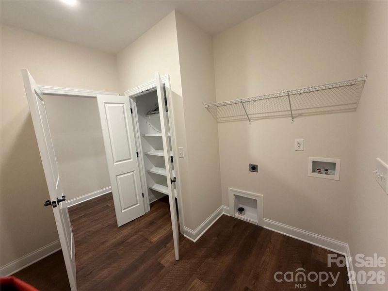 The laundry room has a storage closet with built-in shelving...