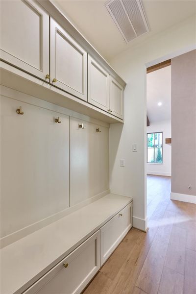 Well-appointed mudroom with built-in storage cabinets, hooks for hanging items, and a bench for convenience. Well-appointed mudroom with built-in storage cabinets, hooks for hanging items, and a bench for convenience.