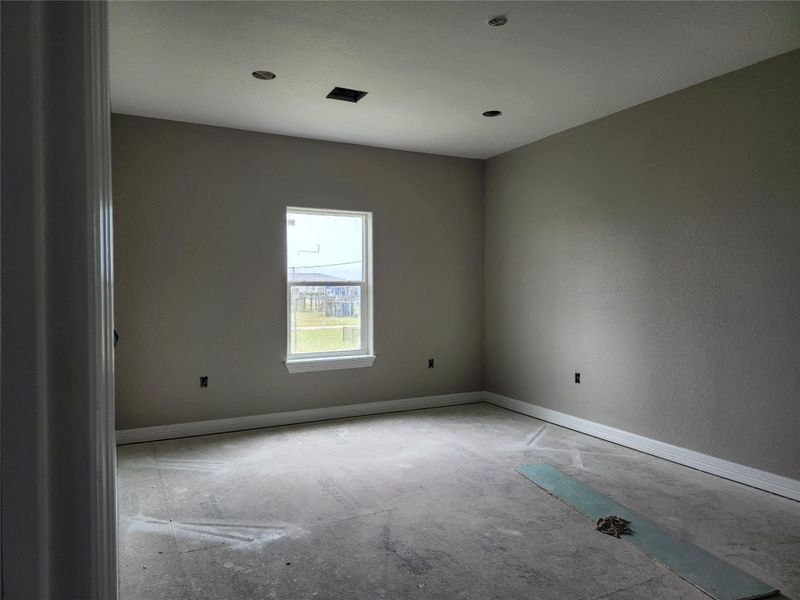 This room features neutral walls, and a large window providing natural light.