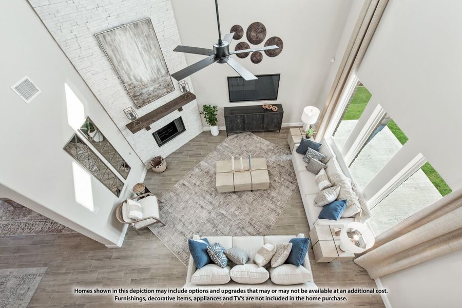 Overhead view of living room with two-story ceiling, white brick fireplace, sectional sofa, and ceiling fan Overhead view of living room with two-story ceiling, white brick fireplace, sectional sofa, and ceiling fan
