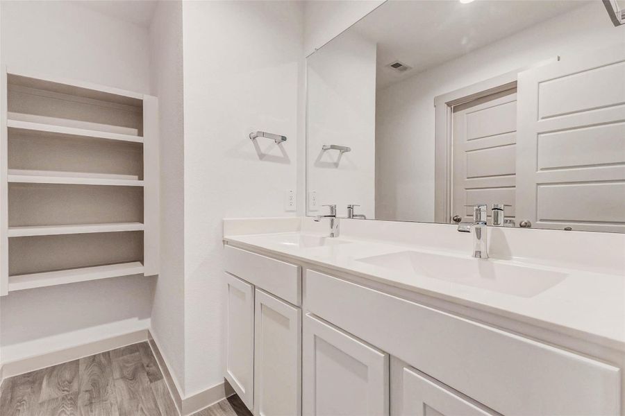 This secondary full bath is built for ease and efficiency with dual vanities, abundant counter space, a wide mirror, and built-in open shelving for towels and storage. Stylish and simple, it’s perfectly suited for shared use or guests. This secondary full bath is built for ease and efficiency with dual vanities, abundant counter space, a wide mirror, and built-in open shelving for towels and storage. Stylish and simple, it’s perfectly suited for shared use or guests.