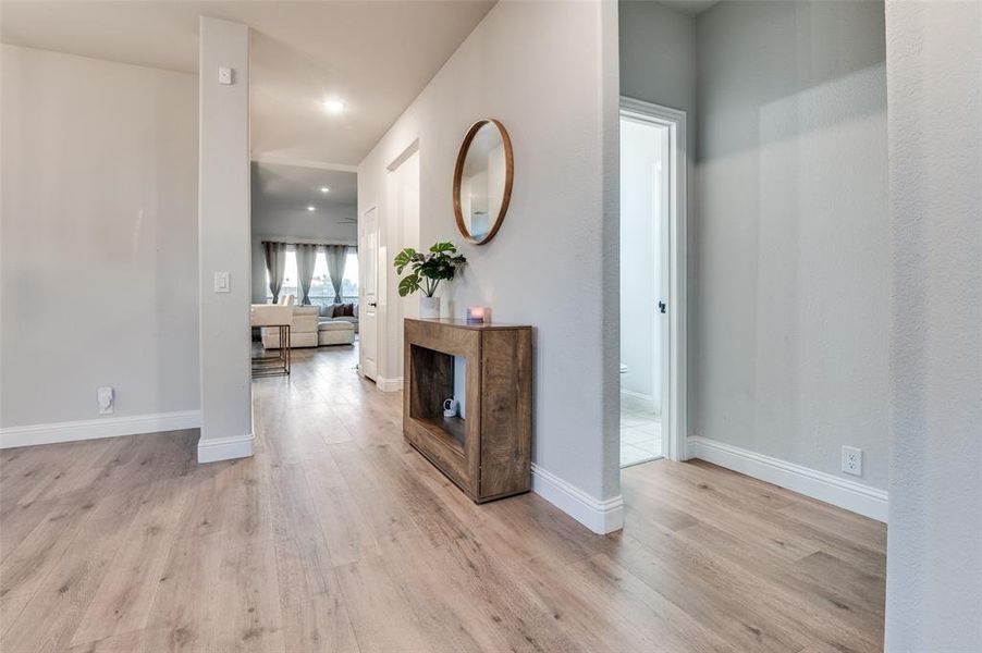 Hall with light wood-style floors and recessed lighting Hall with light wood-style floors and recessed lighting