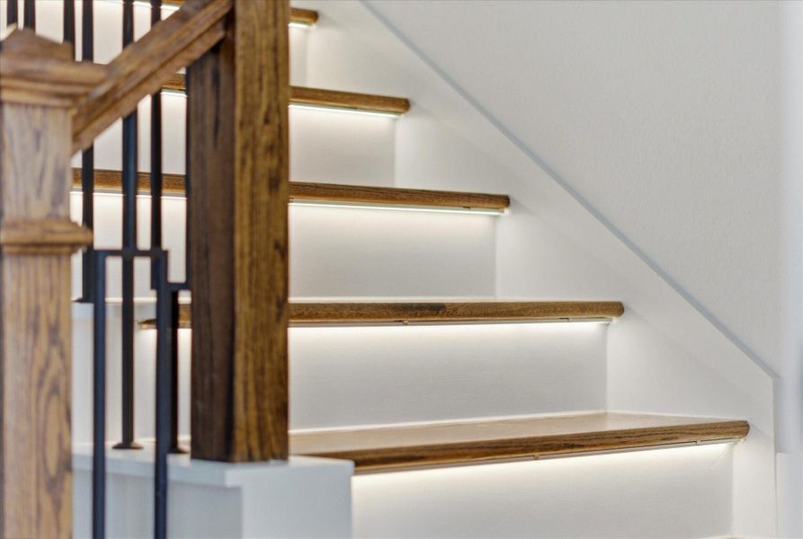 Motion-sensor lighting on the stair treads adds a subtle, elevated touch while enhancing everyday functionality.