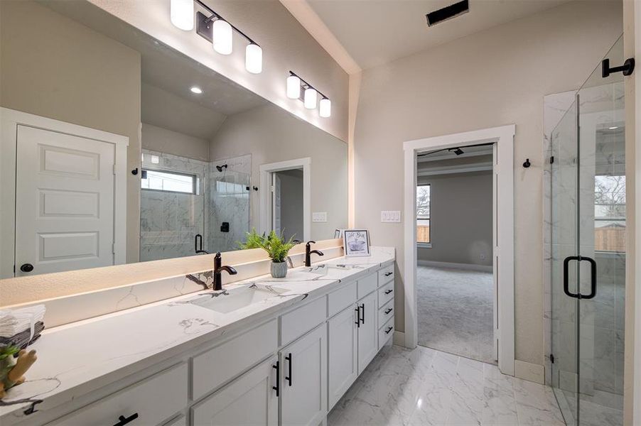 Bathroom with vanity, vaulted ceiling, and walk in shower