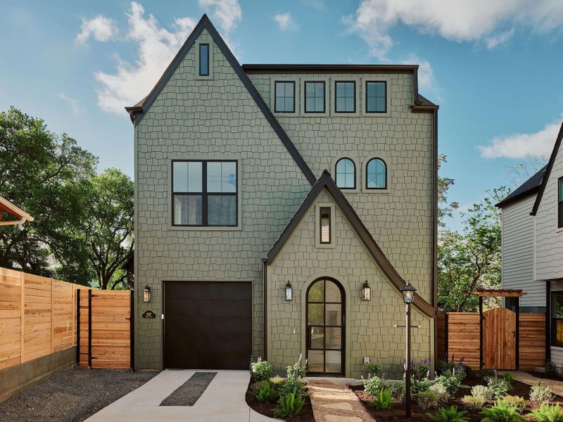 View of front facade with a gate, a garage, and concrete driveway