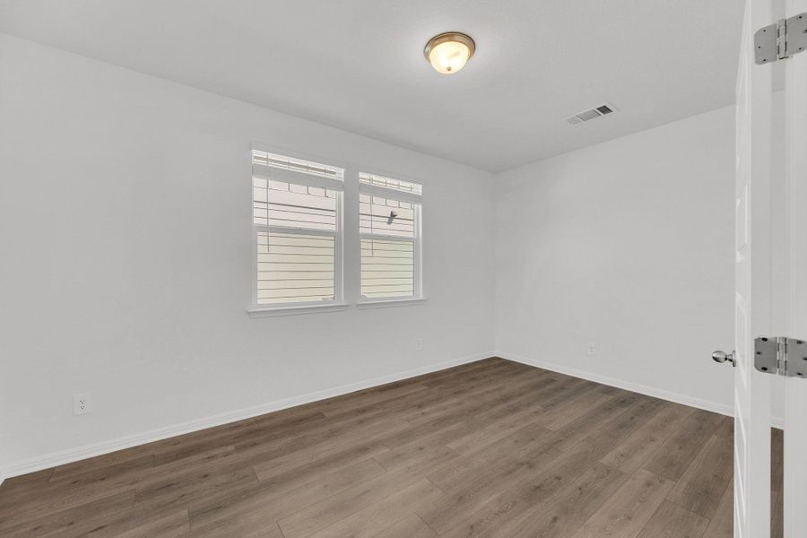Unfurnished room with wood finished floors and baseboards Unfurnished room with wood finished floors and baseboards