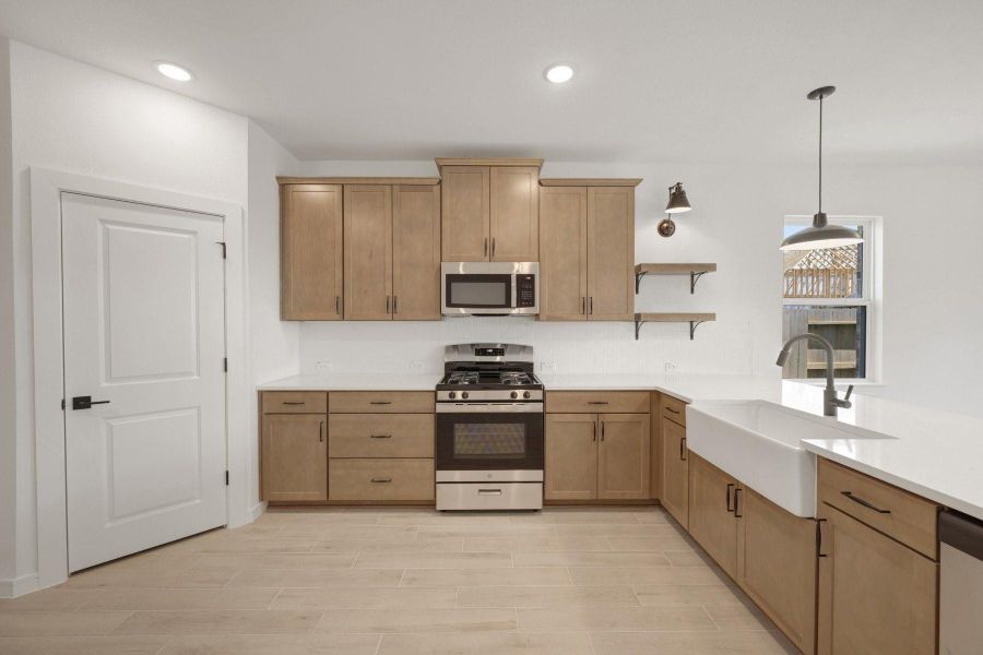 Lovely kitchen with chestnut brown cabinets and floating shelves
