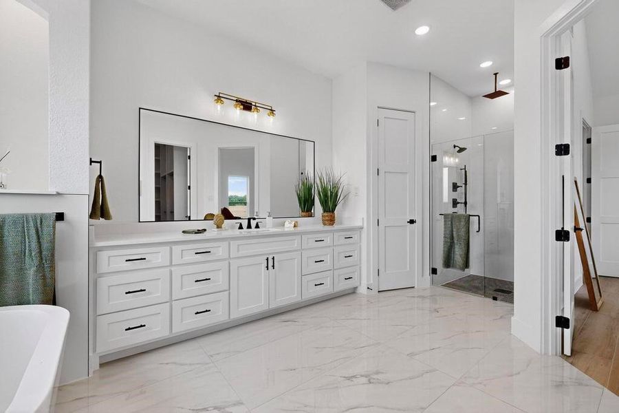 Full bath with a stall shower, vanity, recessed lighting, light marble finish flooring, and a soaking tub Full bath with a stall shower, vanity, recessed lighting, light marble finish flooring, and a soaking tub