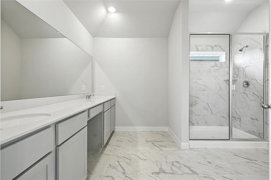 Full bathroom with marble look tiles, a marble finish shower, double vanity, and recessed lighting