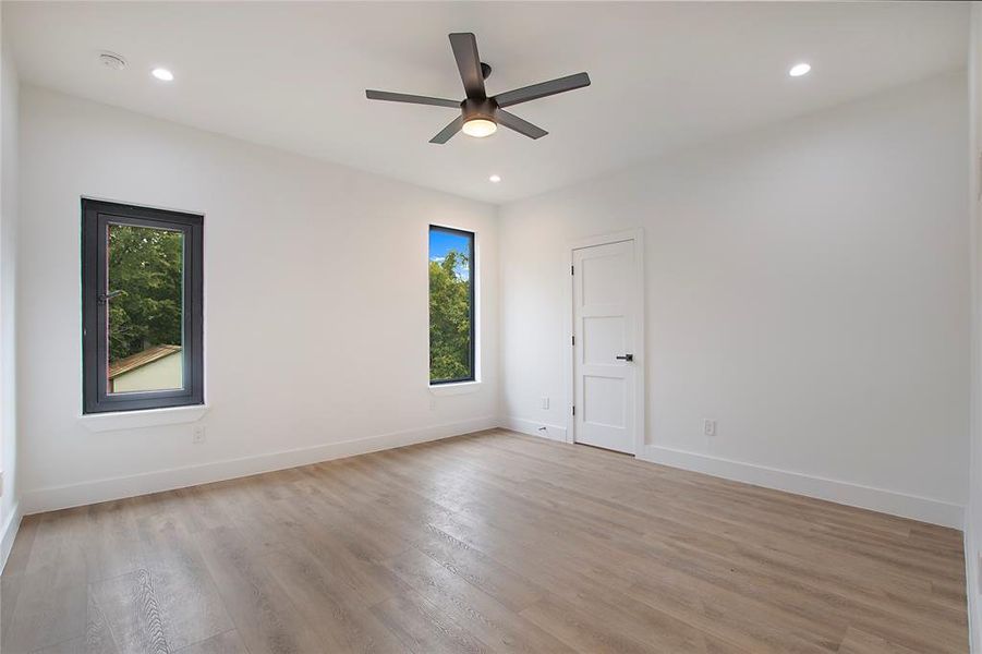 Empty room with ceiling fan and light hardwood / wood-style flooring