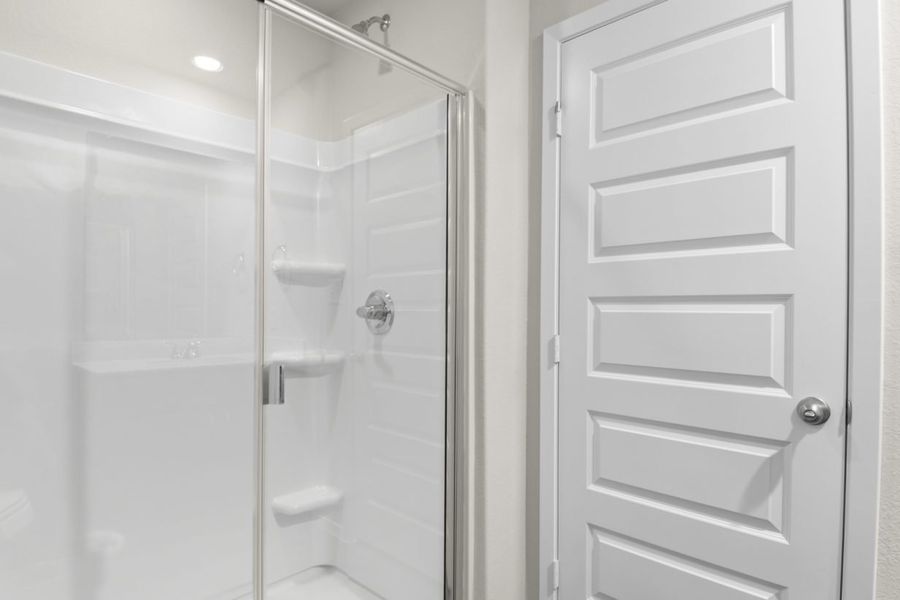Image of a primary bathroom with a white vinyl walk-in shower