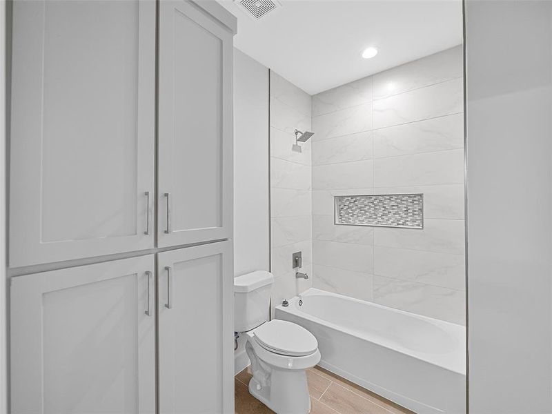 Bathroom 3 with tile patterned flooring, tiled shower / bath combo, and toilet