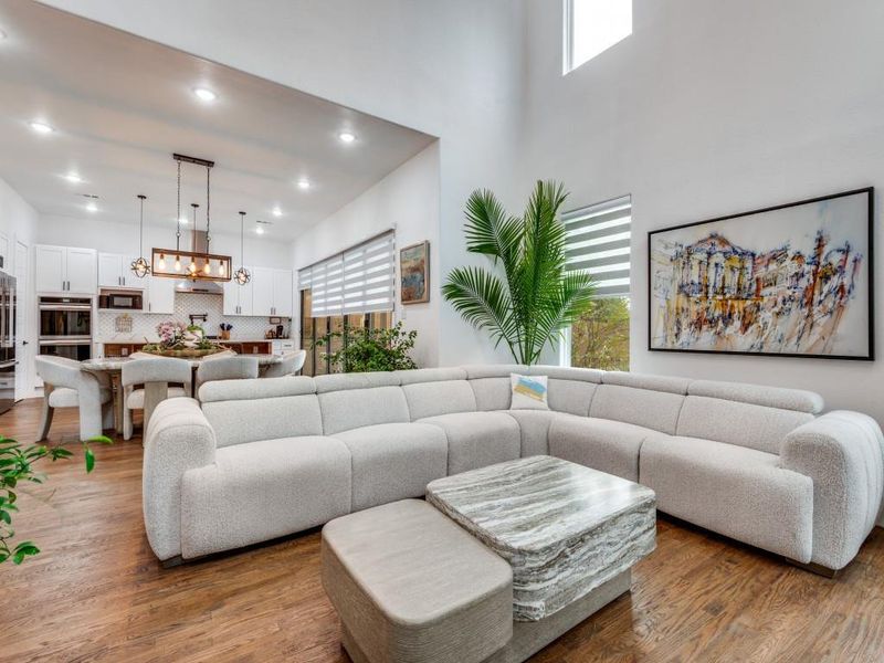 Living area with light wood-type flooring and recessed lighting