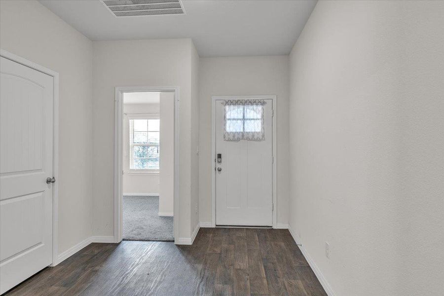 Entryway featuring hardwood-style flooring and a white front door with a window