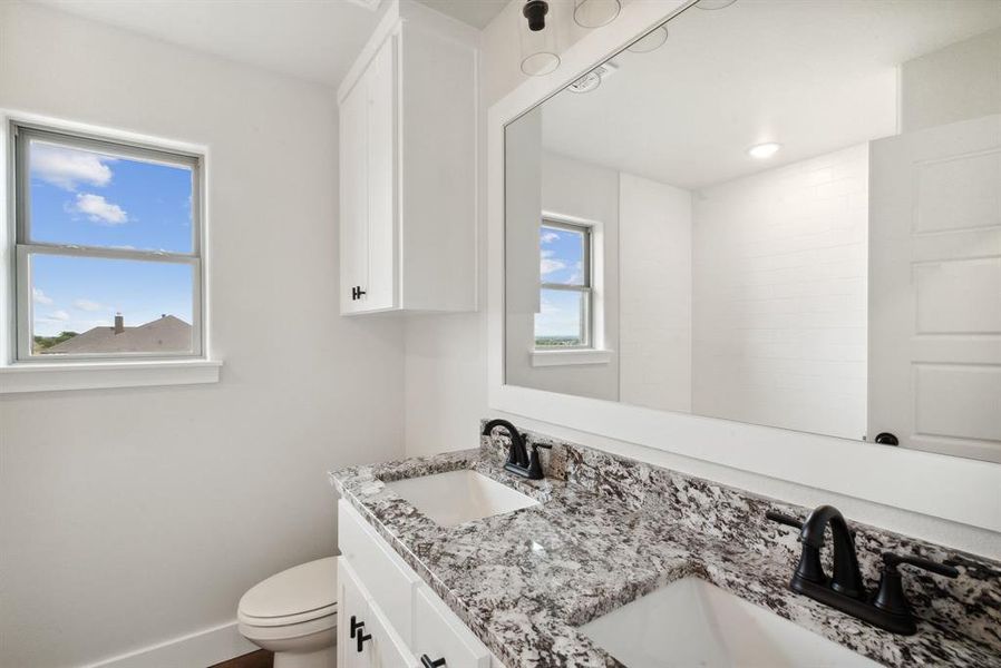 Bathroom with dual vanity and toilet