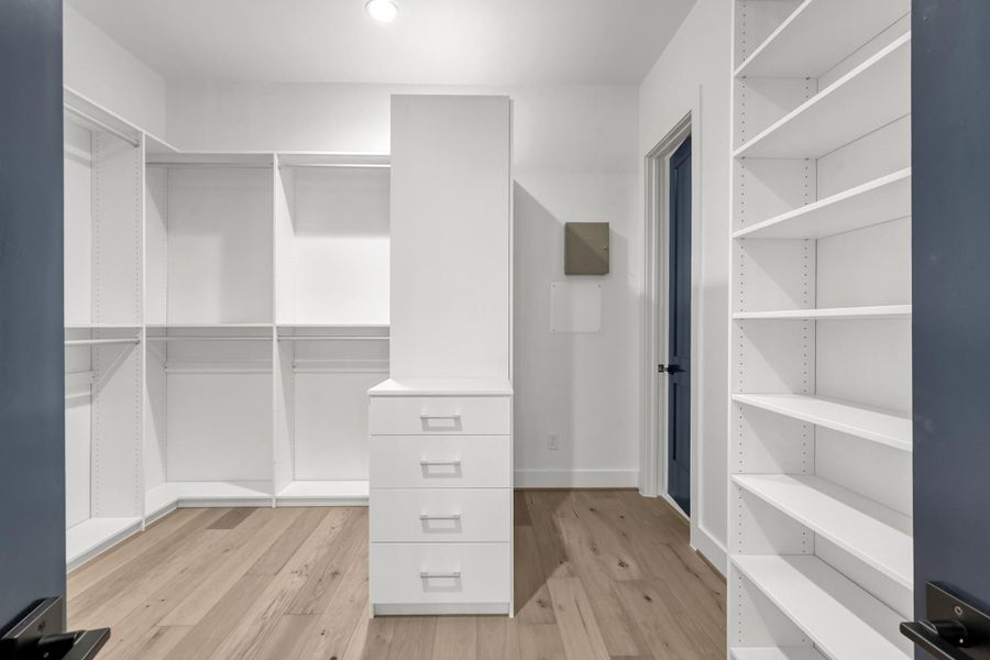 Expansive walk-in closet with built-in shelving and storage solutions. Expansive walk-in closet with built-in shelving and storage solutions.