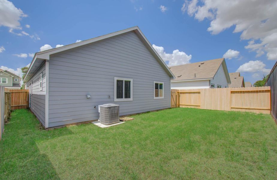 Charming fenced backyard with a lush lawn, perfect for outdoor relaxation and activities.