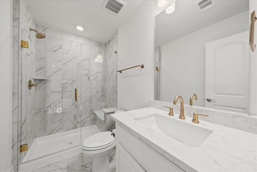 Bathroom with light marble finish flooring, vanity, a marble finish shower, and recessed lighting Bathroom with light marble finish flooring, vanity, a marble finish shower, and recessed lighting