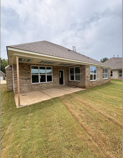 Rear exterior featuring a covered patio, brick facade, numerous windows, and a shingle roof Rear exterior featuring a covered patio, brick facade, numerous windows, and a shingle roof
