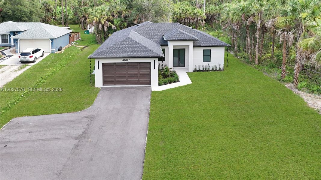 Modern residence featuring a dark shingle roof and a two-car garage