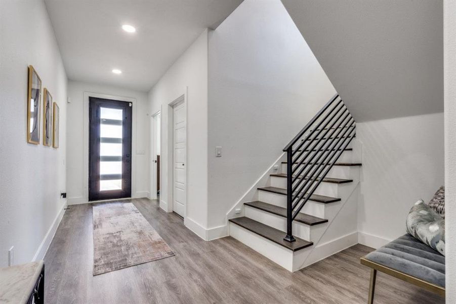 Entryway featuring wood finished floors, stairs, and recessed lighting