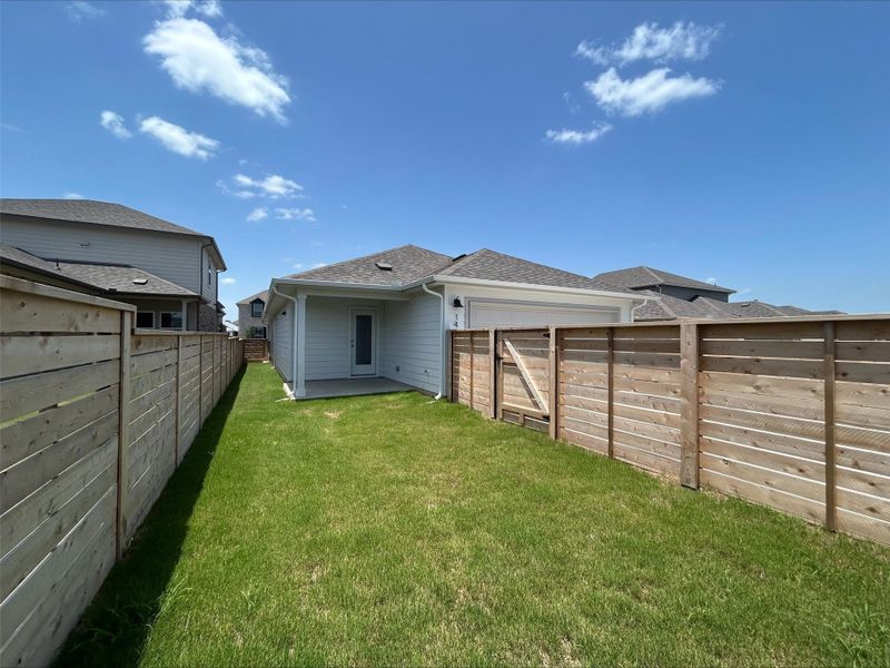 Back of property featuring a shingled roof, a fenced backyard, and an attached garage Back of property featuring a shingled roof, a fenced backyard, and an attached garage