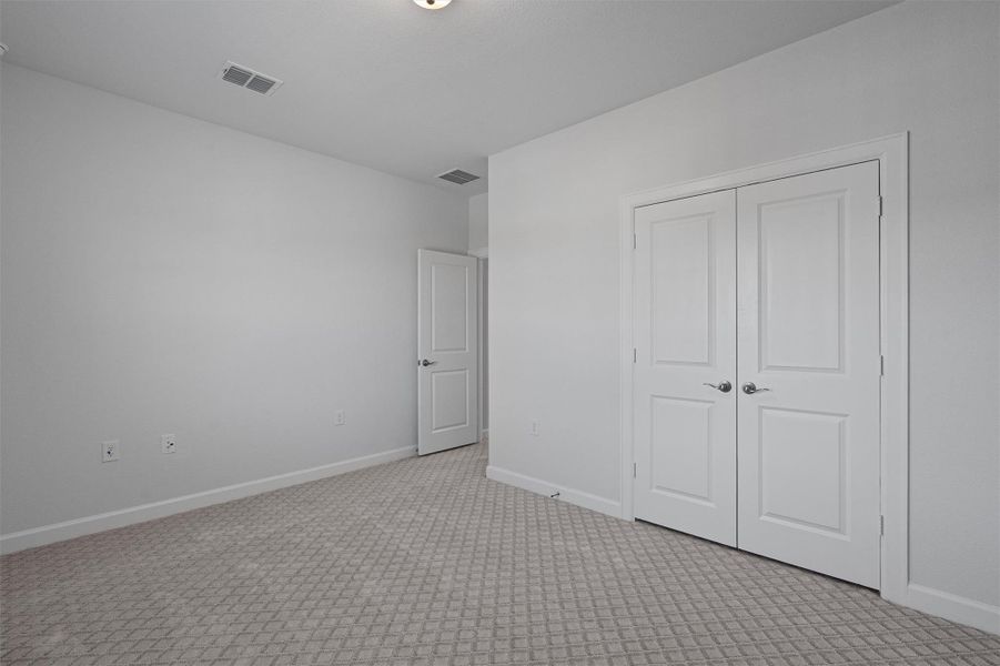 Unfurnished bedroom featuring light colored carpet and a closet Unfurnished bedroom featuring light colored carpet and a closet