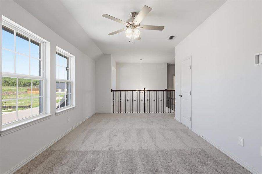 Spare room featuring a ceiling fan and light colored carpet Spare room featuring a ceiling fan and light colored carpet