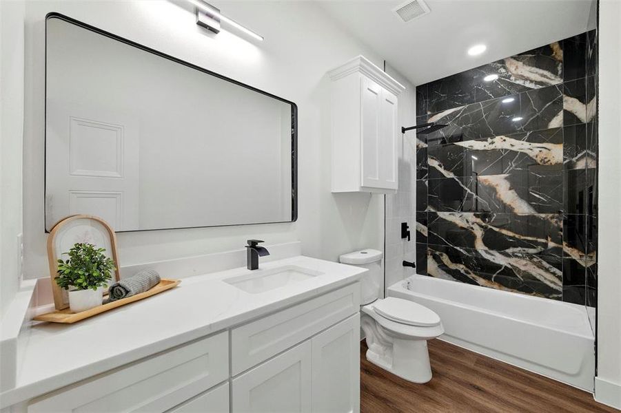 Full bathroom with vanity, wood finished floors, washtub / shower combination, and recessed lighting