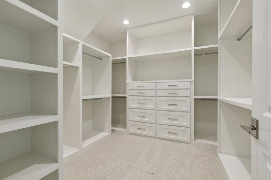 Primary closet with light carpet