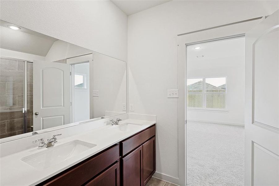 Bathroom featuring a shower with door and vanity