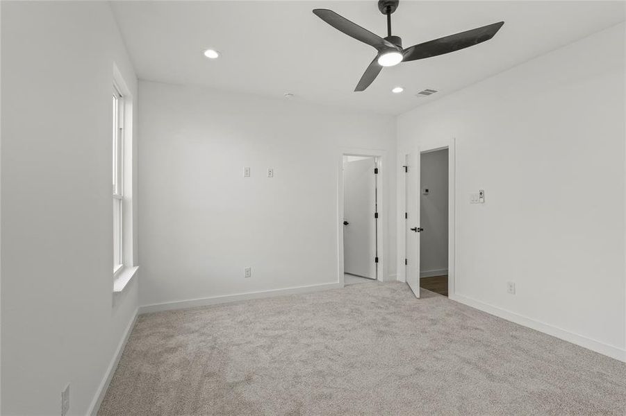 Carpeted spare room featuring ceiling fan