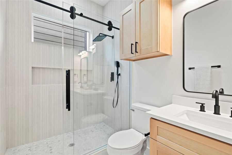 Matte black accents pop against warm maple cabinetry and clean white quartz counters for a look that’s both timeless and on trend.