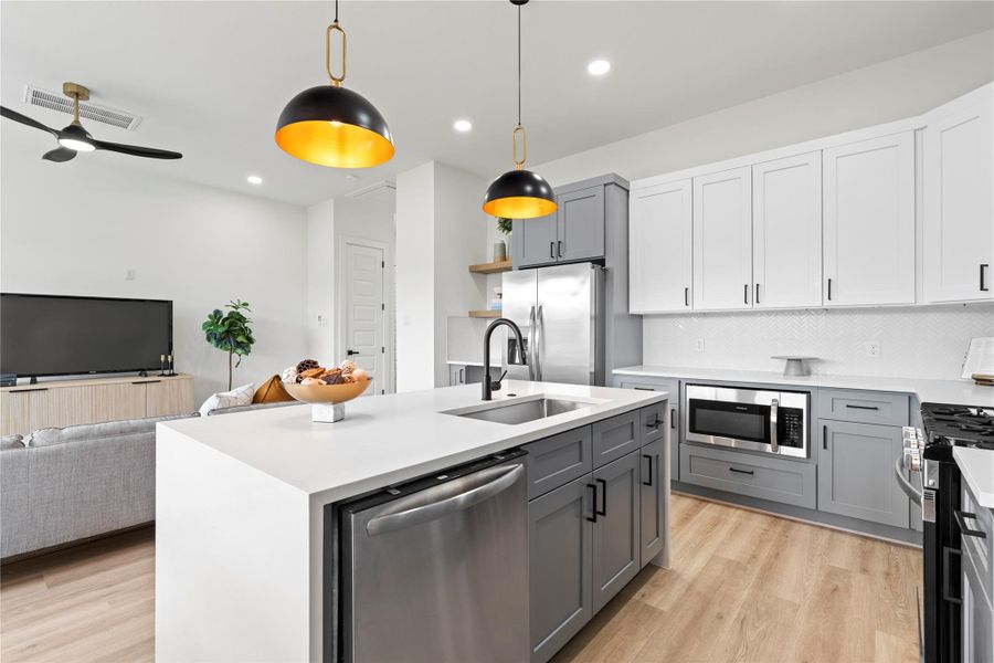 Quartz waterfall countertops, custom millwork, and soft-close cabinetry bring luxury touches to everyday living.