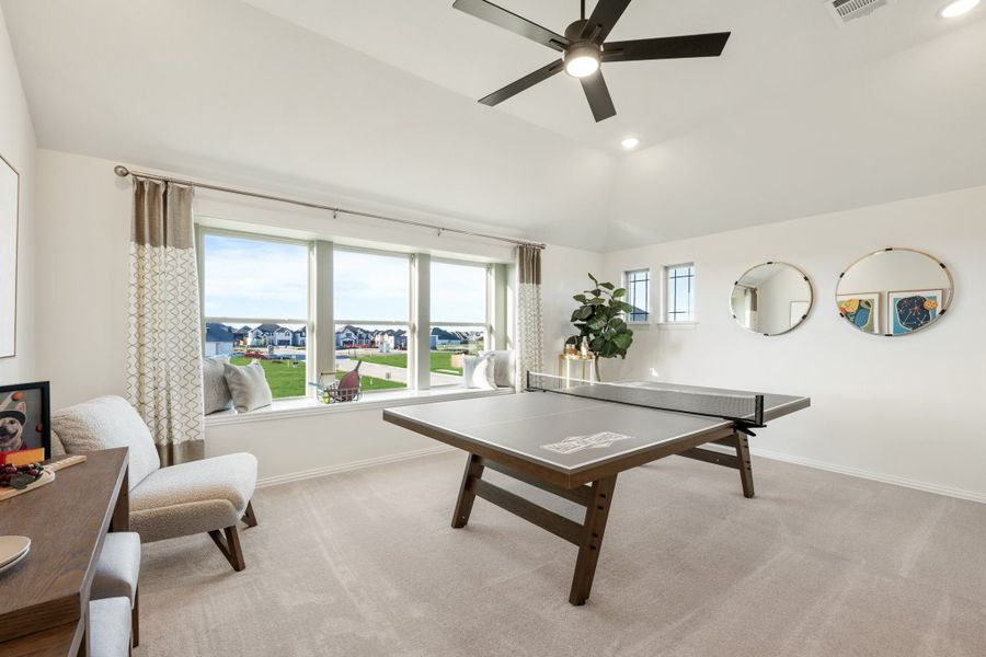 Game room with ping pong table, ceiling fan, carpet flooring, and large windows with neighborhood views