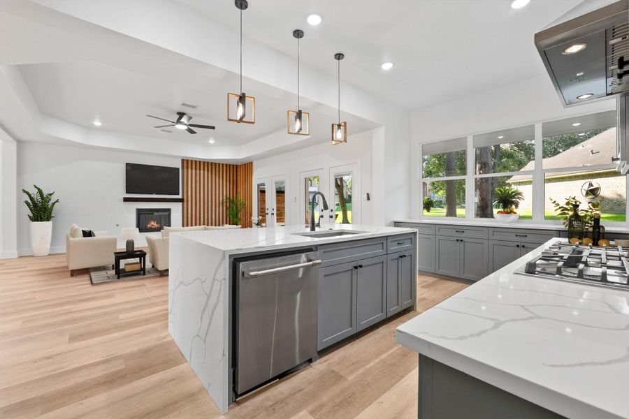 This bright kitchen seamlessly connects to the living room and features custom cabinetry and a sleek stainless steel appliance package. This bright kitchen seamlessly connects to the living room and features custom cabinetry and a sleek stainless steel appliance package.