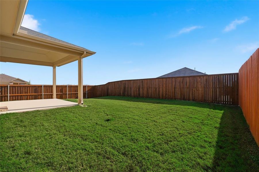 Fenced backyard with a patio area Fenced backyard with a patio area
