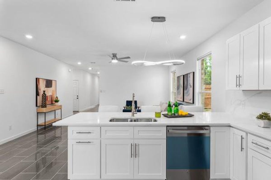 Kitchen featuring a peninsula, dishwasher, white cabinets, recessed lighting, and light stone countertops Kitchen featuring a peninsula, dishwasher, white cabinets, recessed lighting, and light stone countertops