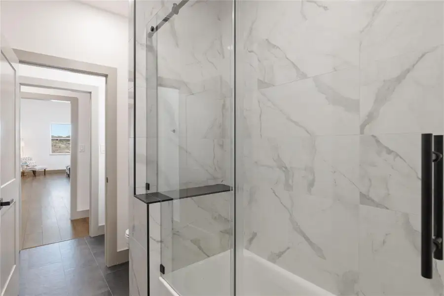 Full bathroom featuring combined bath / shower with glass door and baseboards
