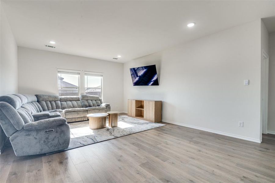 Living area with light wood finished floors and recessed lighting Living area with light wood finished floors and recessed lighting