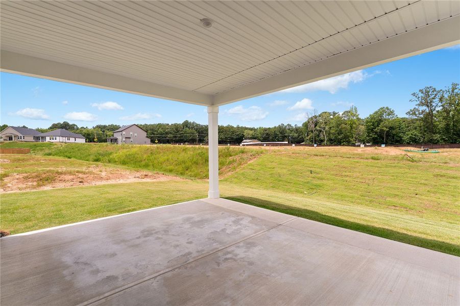 A spacious covered patio overlooks a generous gras