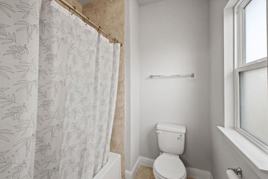 Full bathroom featuring toilet and shower / tub combo Full bathroom featuring toilet and shower / tub combo