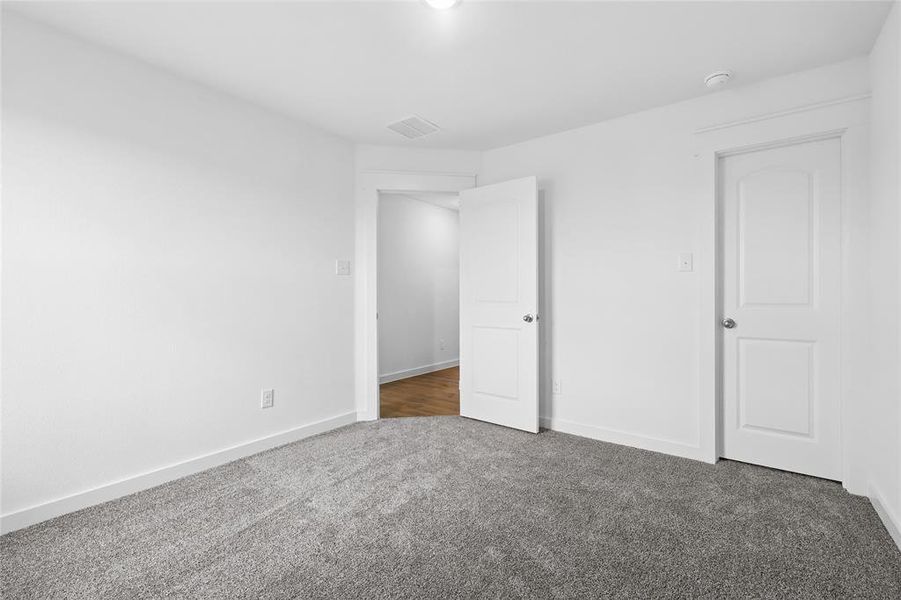 Unfurnished bedroom featuring baseboards and carpet Unfurnished bedroom featuring baseboards and carpet