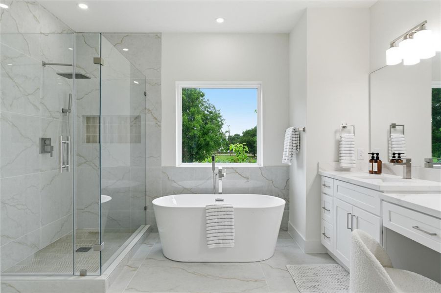 The primary bath elevates the suite with a freestanding soaking tub, glass-enclosed shower, and dual vanity, all set against clean, spa-like finishes.