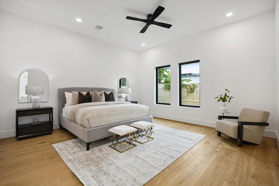 Primary suite conveniently located downstairs with hardwood floors, modern lighting, and en-suite bath. Primary suite conveniently located downstairs with hardwood floors, modern lighting, and en-suite bath.