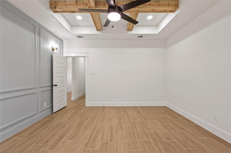 Unfurnished bedroom with beam ceiling, wood tiled floors, coffered ceiling, a ceiling fan, and recessed lighting