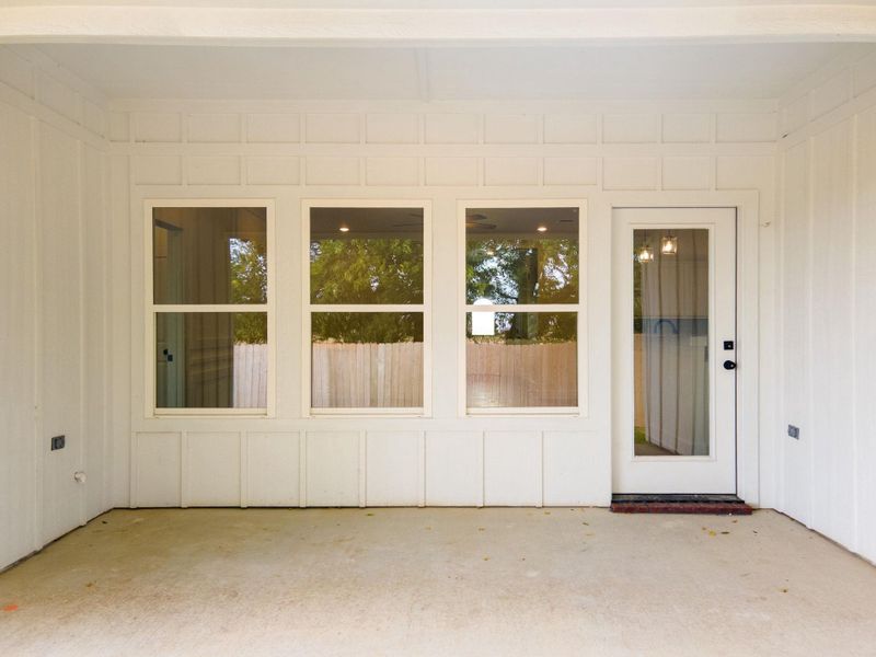 View of exterior entry with a patio and board and batten siding