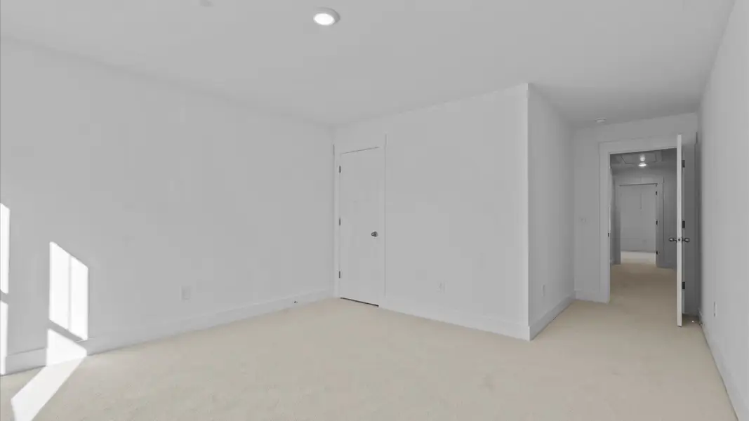 Elegant bedroom retreat featuring soft carpeting and a thoughtfully designed walk-in closet