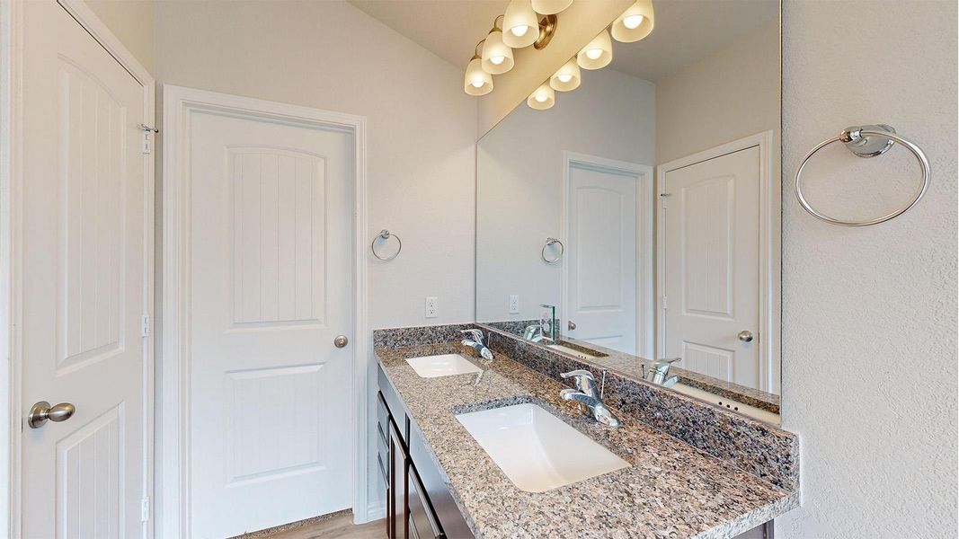 Double vanity with granite countertop, two undermount sinks, and chrome faucets Double vanity with granite countertop, two undermount sinks, and chrome faucets